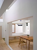 Schlichter Stuhl und Tisch aus Holz im Bauhausstil im modernen Haus mit Ausschnitten in Wand