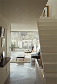 Open stairway with wide passageway and view of an armchair in a modern living room