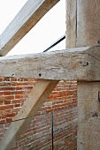 Detail of old, wooden construction and glass balustrade in front of a brick wall