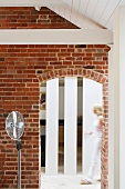Photo floor lamp in front of a brick wall with round arch