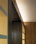 Wood built-in with integrated white shelves and indirect light under the ceiling