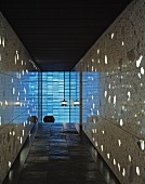 Hallway with light reflecting off the stone wall tiles and slate tiles on the floor