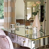 A dressing table with a mirrored surface and a three-way mirror