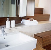 A modern wash basin with bathing utensils on a shelf