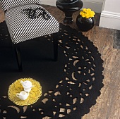 Stuhl mit gestreiftem Bezug auf einem runden schwarzen Teppich