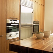 Eine Einbauküche mit Holzfronten und Edelstahl-Kühlschrank