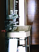 A retro-style washstand with bathing utensils on a shelf in front of a natural stone wall
