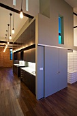 Kitchen, bathroom and stairwell window illuminated in coloured light in central, compact unit in a London loft apartment