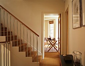 Wall-to-wall sisal carpeting in hall with staircase and adjacent dining room