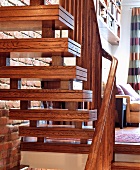 Wooden stairs with treads ornamented with double grooves and wooden balustrade in living room