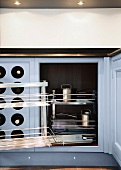 A kitchen cupboard with a pull-out steel shelf