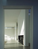 A view through a wide doorway into a minimalistic living room in a contemporary house
