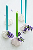 Kerzen in Kerzenständern aus Baiser mit Lavendelblüten dekoriert