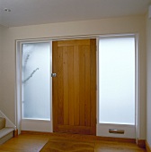 Foyer with wooden front door and opaque door-height windows