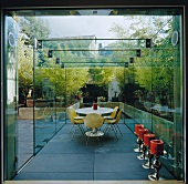 Contemporary glass conservatory with dining area and floor candlesticks