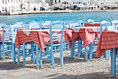 Tische einer griechischen Taverne am Hafen; rot-weiss karierte Tischdecken sorgen für eine heitere Stimmung