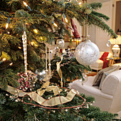 Christmas tree decorated with fairy lights and silver baubles in the living room