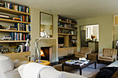 Living room with fireplace and built-in bookshelves, cosy armchairs and sofa