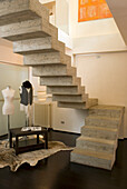 Concrete staircase in modern living room with tailor's dummies