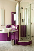 Badezimmer mit Duschkabine und lila Farbakzenten