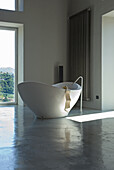 Freestanding bathtub in minimalist bathroom with view to the outside