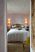 Rustic bedroom with golden mirror and wall lamps