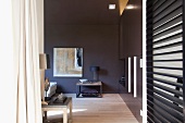 Beistelltisch vor dunkelgrau getönter Wand in Designer Wohnzimmer und Holzlamellen-Raumteiler