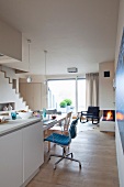 Küche mit Küchentheke im offenen, skandinavisch inspirierten Wohnraum mit Gaskamin