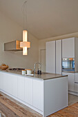 Modern kitchen with cooking island with white fronts