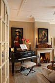 View though open door of grand piano next to fire in open fireplace