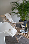 Wooden deckchair with white towel and champagne