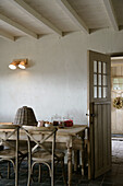 Rustikaler Esstisch mit Stühlen und klassischer Holztür im Landhausstil