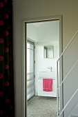 Open door in stairwell with view into modern bathroom