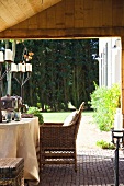 Gedeckter Tisch mit rustikalen Kerzenleuchtern und Blick in Garten vor Waldrand