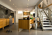 Loft-style kitchen with cooking island and metal staircase