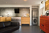 Modern kitchen with wooden elements, leather sofa and industrial cupboard