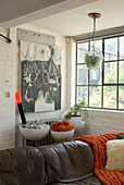 Wohnraum mit braunem Leder-Sofa und diversen Kunstwerken