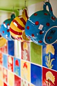 Colourful cups on hooks