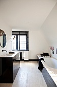 Washstand and bathtub with black-painted panelling in white, designer bathroom