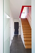 Treppenaufgang im minimalistischen Flur mit Natursteinboden