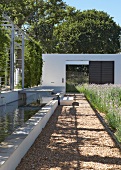 Contemporary landscaping - sunny gravel path edged by meadow and water feature