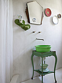 Green wash bowl on antique table, mirror and wall decoration