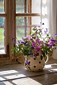 Spring bouquet in rustic jug on windowsill