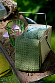 Cloths in a cardboard box next to a glass with petals