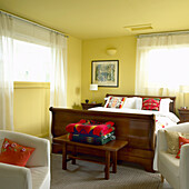 Bedroom with wooden bed and colorful blankets and pillows