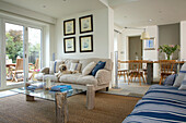 Open-plan living area with sofas, dining area, dog and view of the garden