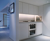 White kitchenette in open-plan living space