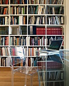Acrylglasmöbel vor Bücherwand