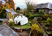 Traditionelles Steinhaus und Garten mit Zelt in Herbstlandschaft