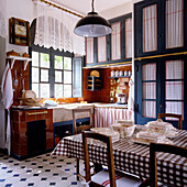 Country kitchen with chequered tablecloths and patterned tiled floor